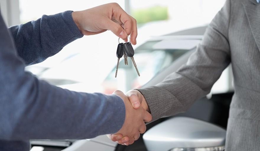 People shaking each other hands while holding keys