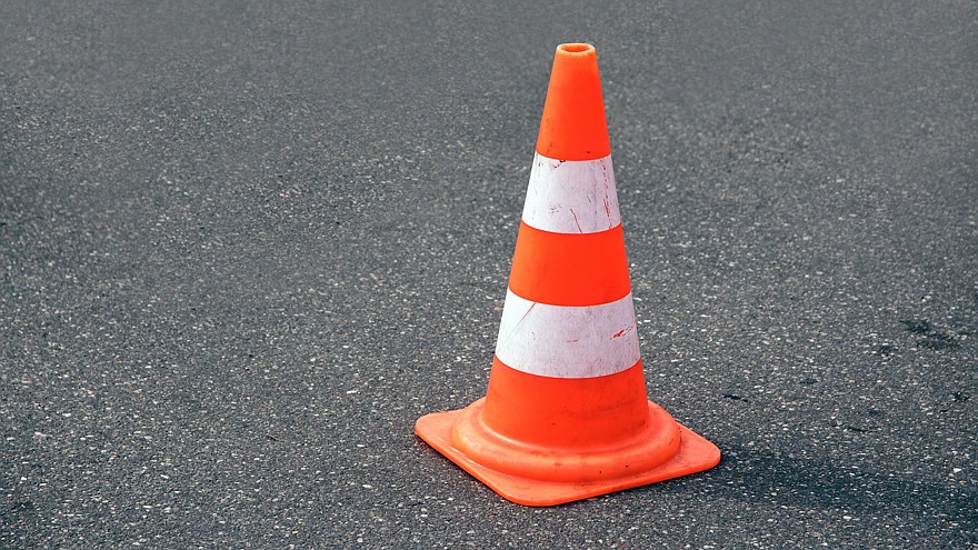 traffic cone, white and orange on gray asphalt, copy space