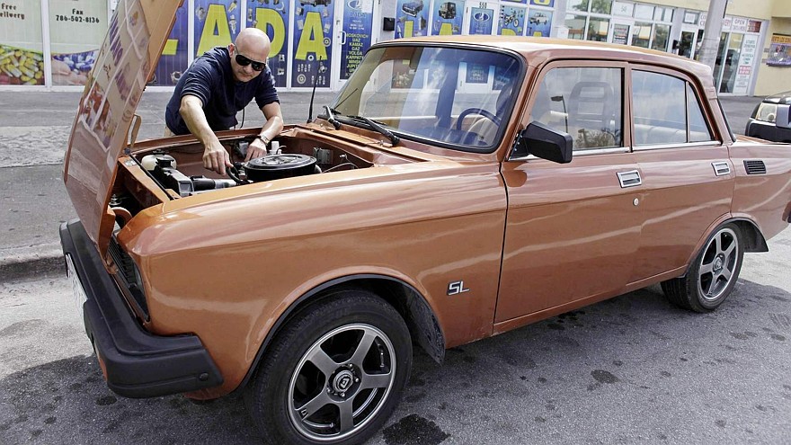 Lester Luis checks a Moskvich in front of Fabian Zakharov's Zakharov Auto Parts shop in Hialeah